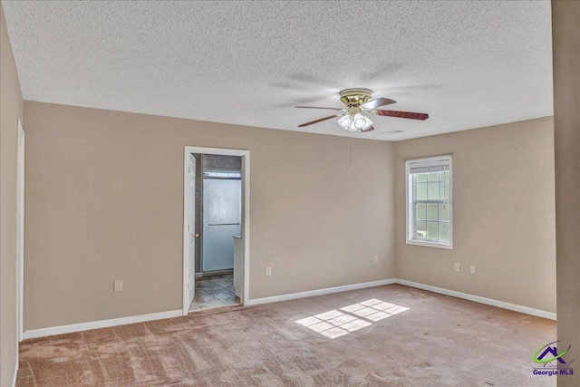 carpeted spare room featuring a textured ceiling and ceiling fan