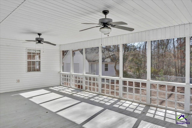 unfurnished sunroom featuring ceiling fan