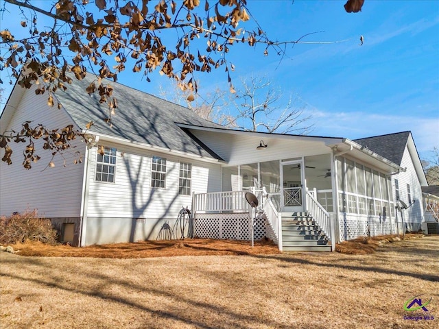 view of front of home with a sunroom, a front yard, and ceiling fan