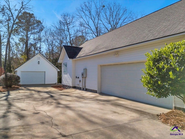 view of side of home featuring a garage and an outdoor structure