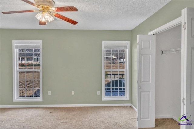 unfurnished bedroom featuring carpet, a textured ceiling, and a closet