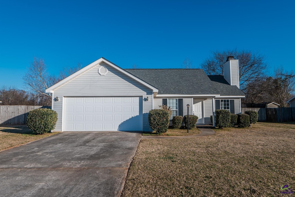 ranch-style house with a garage and a front lawn