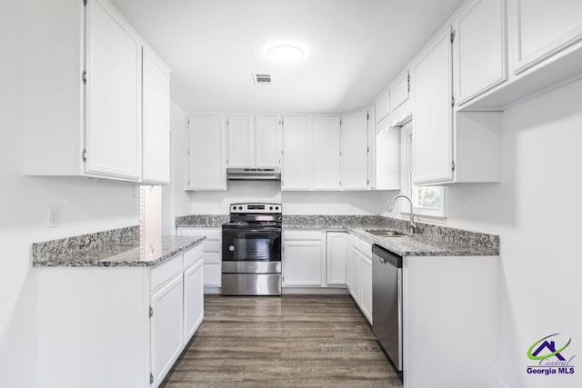 kitchen featuring sink, appliances with stainless steel finishes, dark hardwood / wood-style floors, light stone countertops, and white cabinets