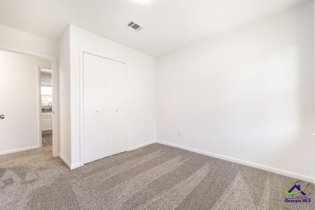 unfurnished bedroom with a closet and carpet