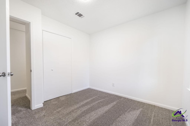 unfurnished bedroom featuring carpet floors and a closet