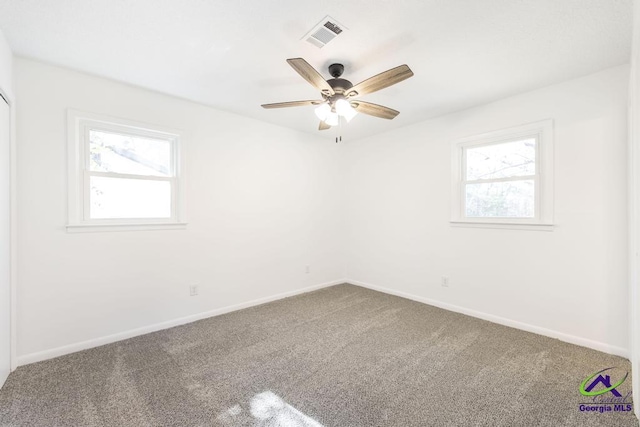 empty room featuring ceiling fan, plenty of natural light, and carpet flooring