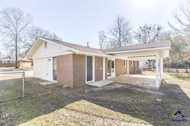 back of property with a lawn and central air condition unit