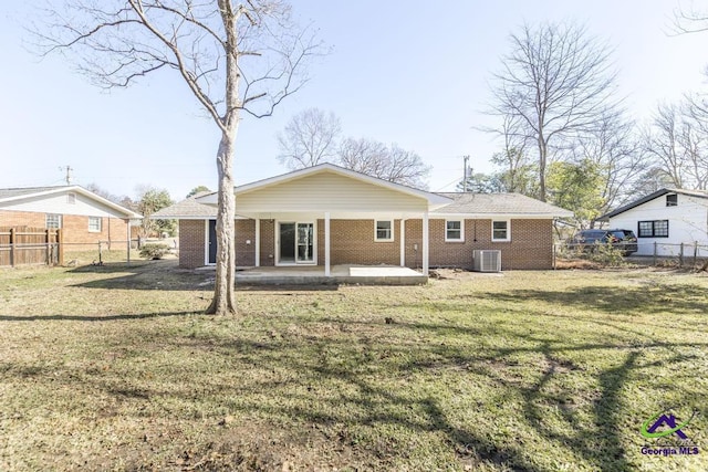 rear view of property with cooling unit, a patio, and a lawn