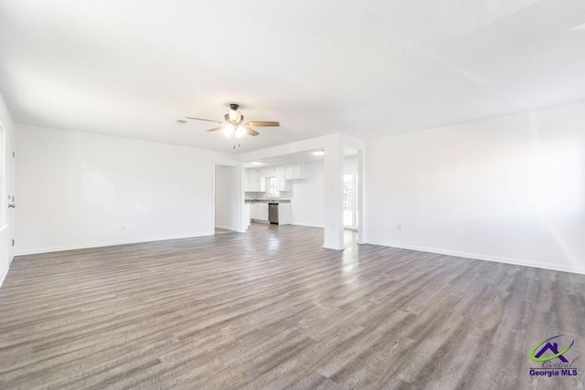 unfurnished living room with hardwood / wood-style flooring and ceiling fan