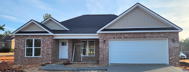 view of front of house featuring a garage, concrete driveway, and brick siding