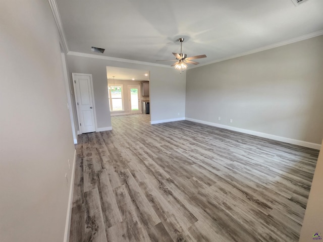 empty room featuring light wood-style floors, baseboards, visible vents, and ornamental molding