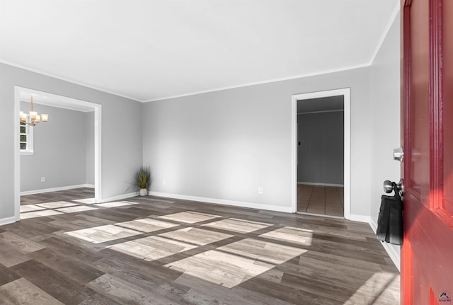 spare room with crown molding, dark hardwood / wood-style floors, and a notable chandelier