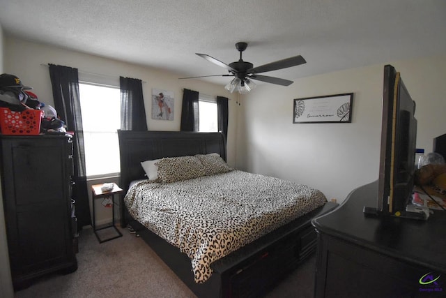 carpeted bedroom with ceiling fan and a textured ceiling