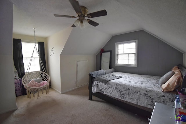 bedroom featuring vaulted ceiling, light carpet, ceiling fan, and a textured ceiling