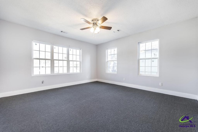 carpeted spare room with ceiling fan and a textured ceiling