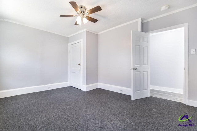 unfurnished bedroom with ceiling fan, ornamental molding, and dark carpet