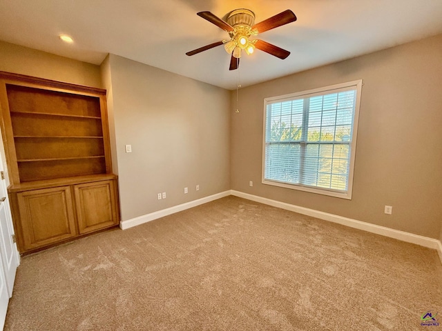 carpeted empty room featuring ceiling fan