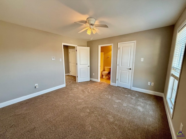 unfurnished bedroom with ceiling fan, carpet floors, and ensuite bath