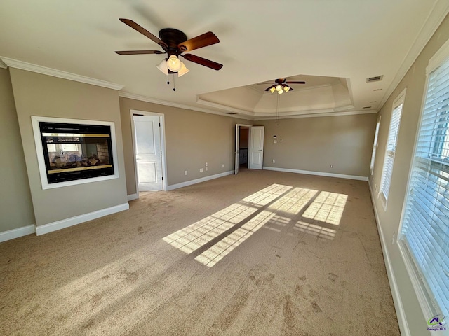 interior space featuring ornamental molding, a multi sided fireplace, ceiling fan, and a tray ceiling