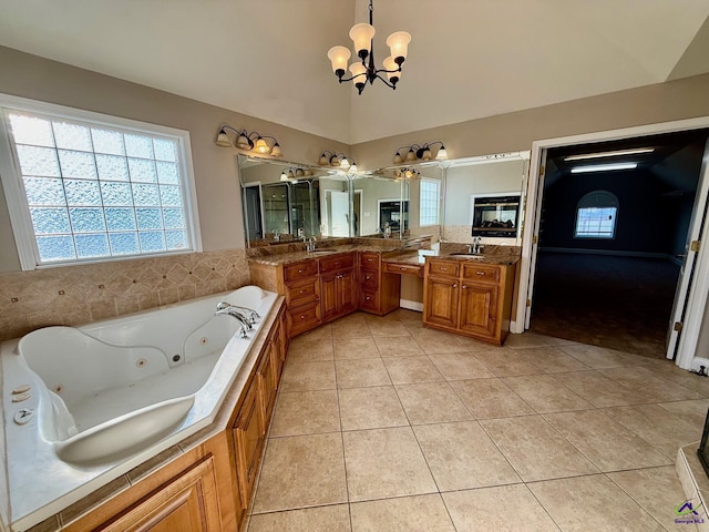 bathroom featuring vaulted ceiling, a tub, a chandelier, vanity, and tile patterned floors