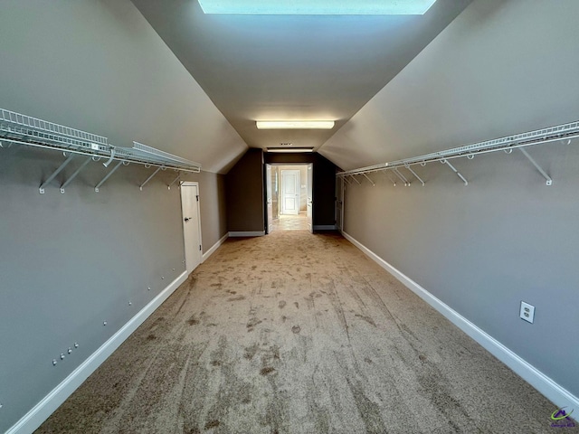 walk in closet featuring light carpet and lofted ceiling