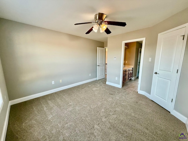 unfurnished bedroom with connected bathroom, light colored carpet, and ceiling fan