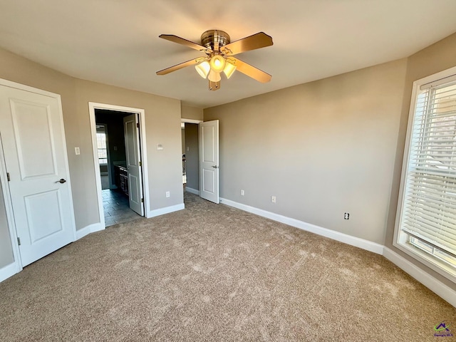 unfurnished bedroom with ensuite bathroom, carpet flooring, and ceiling fan