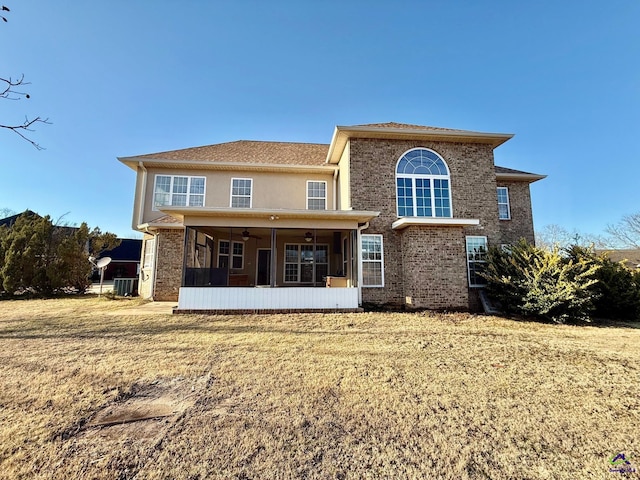 back of property with a lawn, ceiling fan, and central air condition unit