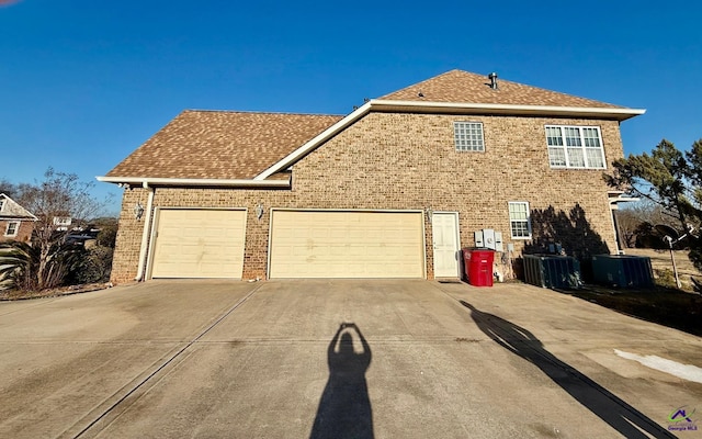 exterior space featuring a garage and cooling unit