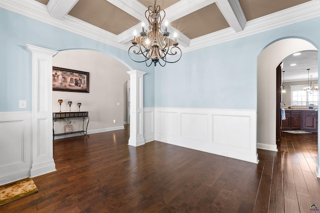 unfurnished dining area with dark wood-type flooring, decorative columns, coffered ceiling, a notable chandelier, and beamed ceiling