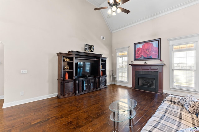 living room with dark wood-type flooring, ceiling fan, crown molding, and high vaulted ceiling