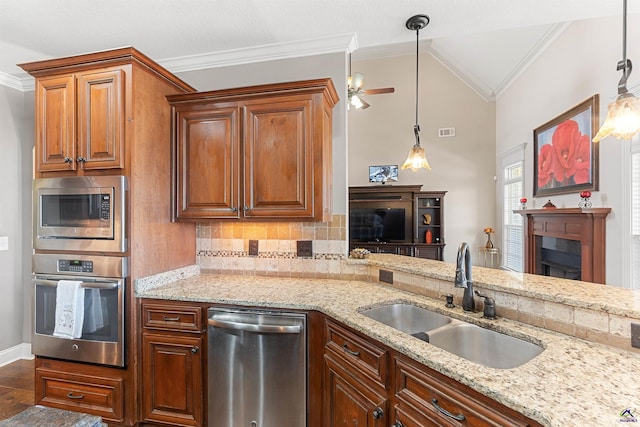 kitchen with ornamental molding, appliances with stainless steel finishes, sink, and hanging light fixtures