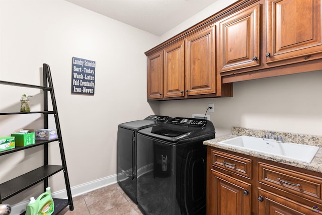 clothes washing area with sink, light tile patterned floors, cabinets, and independent washer and dryer