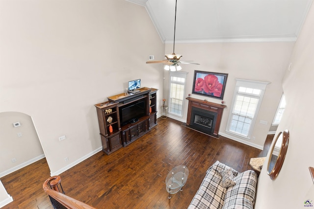 living room with ceiling fan, ornamental molding, dark hardwood / wood-style floors, and high vaulted ceiling