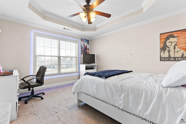 bedroom featuring crown molding, a tray ceiling, ceiling fan, and carpet