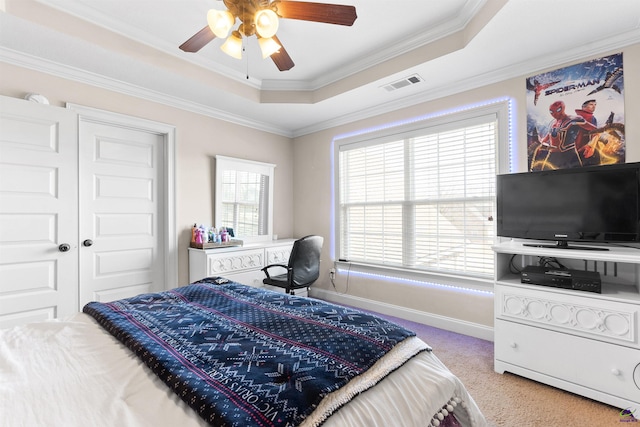 carpeted bedroom featuring a raised ceiling, ornamental molding, and ceiling fan