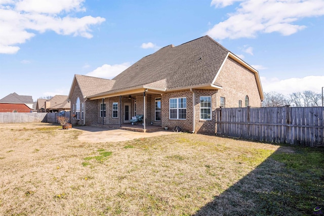 back of property featuring a yard and a patio