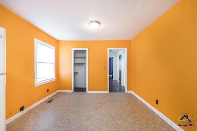 unfurnished bedroom featuring a spacious closet