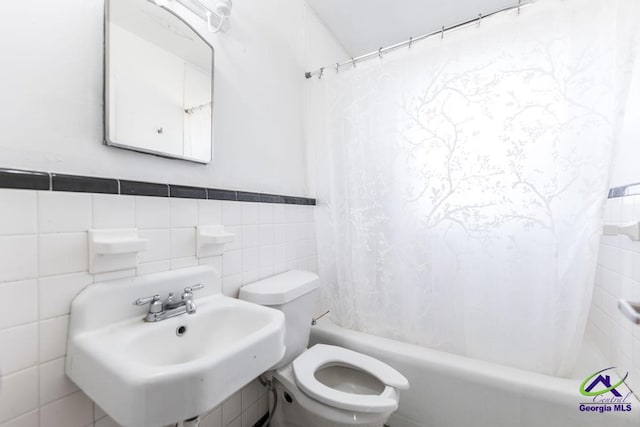 full bathroom with toilet, sink, tile walls, and shower / bath combo