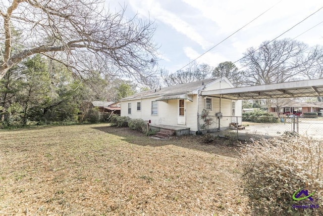 view of side of home featuring a carport and a lawn