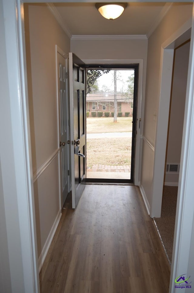 doorway to outside featuring ornamental molding and wood-type flooring