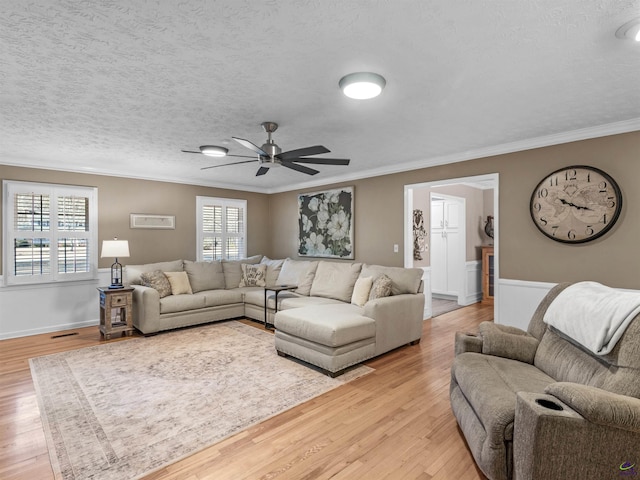 living room with crown molding, a textured ceiling, and light hardwood / wood-style flooring