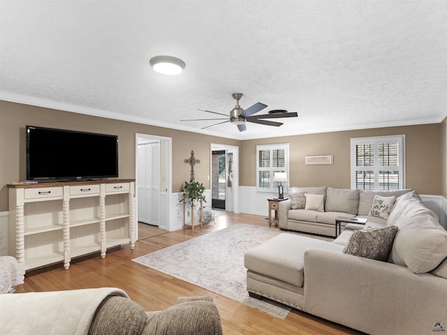 living room featuring ornamental molding, hardwood / wood-style floors, and a textured ceiling