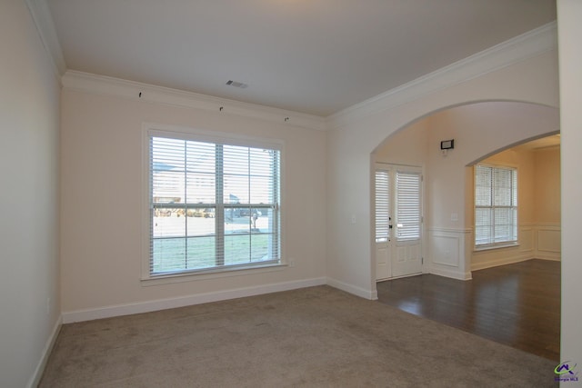 unfurnished room featuring crown molding and dark carpet