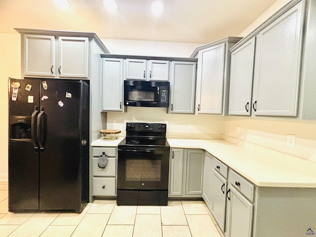 kitchen with light tile patterned flooring, gray cabinets, and black appliances