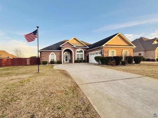 ranch-style home featuring a garage and a yard