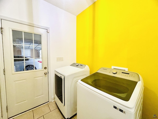 clothes washing area featuring separate washer and dryer and light tile patterned floors