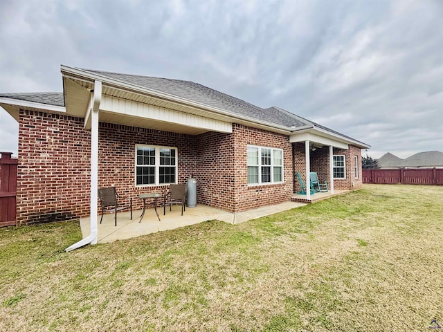 rear view of property with a yard and a patio