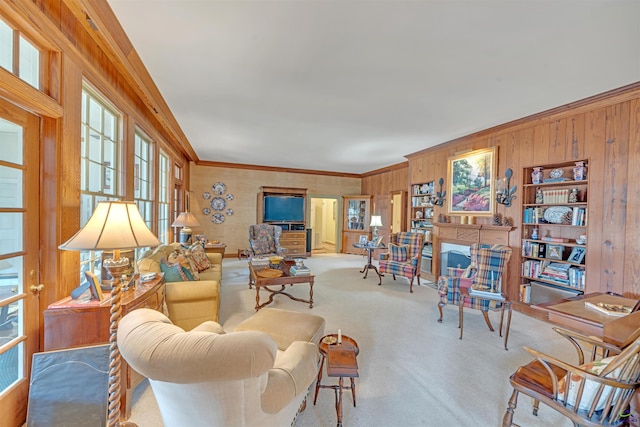 carpeted living room with crown molding and wood walls