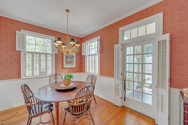 dining area with crown molding, light hardwood / wood-style flooring, and a chandelier